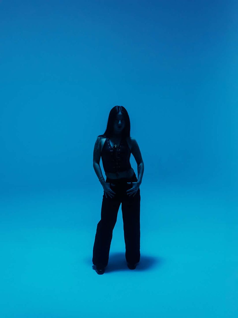 LilyannaMarie standing full-length against a blue backdrop.